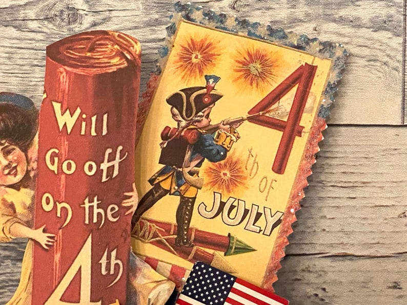 May include: Vintage Fourth of July themed paper cutouts. One cutout features a soldier aiming a rifle with the text "4th of July". Another cutout reads "Will Go off on the 4th". Includes a small American flag.