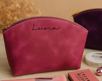 May include: Two cosmetic bags, one magenta and one purple, with gold zippers. The magenta bag has "Luna" written on it. Makeup items include a blush brush, cream blush, mascara, lip gloss, and a compact.
