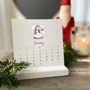 Calendrier de bureau Favoris 2025 par Tina Labadini Designs. Notre meilleur art de l'année, calendrier et support en bois, nouveau papier cartonné amélioré