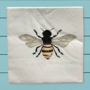 May include: A white paper napkin with a watercolor illustration of a bee. The bee has black and yellow stripes and translucent wings.