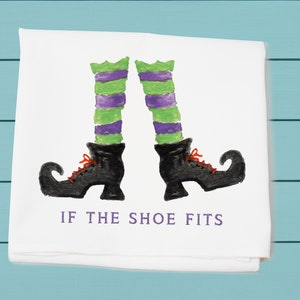 May include: White kitchen towel with a black and green witch's leg and shoe illustration. The text "IF THE SHOE FITS" is printed below the illustration.