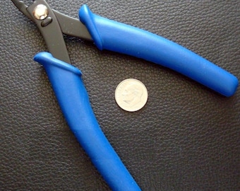 May include: Blue handled pliers with black jaws for jewelry making. The pliers are next to a US quarter for size comparison.