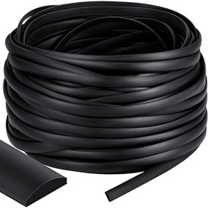 May include: A coiled roll of black rubber trim, with a section of the trim detached and lying flat. The trim has a rounded top and a flat bottom. The product is likely used for edging or sealing.