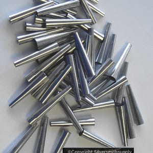 May include: A pile of silver-colored metal cones, likely used for jewelry making or other crafts.  Copyright Silversmithsupply.