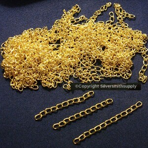 May include: A large pile of gold-coloured chain links. Three smaller pieces of chain are laid out on a blue surface. ©Copyright Silversmithsupply
