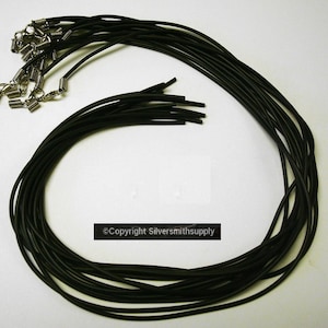 May include: A bundle of 20 black elastic cord necklace chains with silver spring ring clasps.  The cords are approximately 18 inches long.
