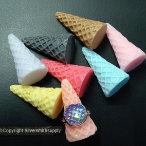 May include: Assortment of ten miniature ice cream cones in various colors, including pink, blue, yellow, white, and brown. The cones are made of a smooth, hard material and are perfect for crafting or decorating.