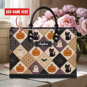 May include: A rectangular handbag featuring a quilted diamond pattern with alternating illustrations of orange pumpkins, black cats, white ghosts, bats, and spiderwebs. The bag has black leather handles and a central black label with the name Sophia.