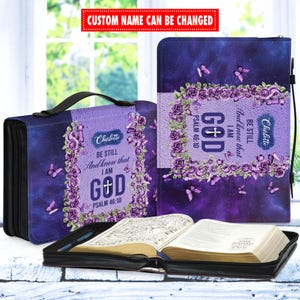 May include: Purple and black Bible cover with a floral design and the text "Be still and know that I am God, Psalm 46:10".