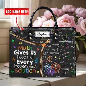 May include: A black rectangular handbag featuring a colorful math-themed print with various equations, geometric shapes, and the text "Math Gives Us Hope That Every Problem Has A Solution." It includes a white name tag with "Sophia" and a zipper graphic.