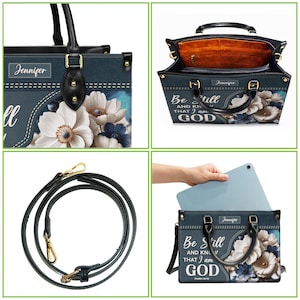 Puede incluir: Un bolso tote azul con un dise&ntilde;o floral y el texto "Be Still and Know that I am God" impreso en la parte delantera. El bolso tiene un asa superior y una correa de hombro desmontable.