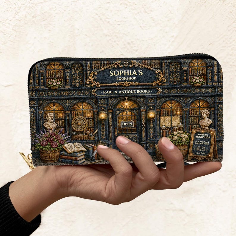Puede incluir: Un monedero con una ilustraci&oacute;n detallada de "Sophia's Bookshop". El dise&ntilde;o muestra una fachada de librer&iacute;a vintage con detalles arquitect&oacute;nicos ornamentados, bustos y el texto "Rare & Antique Books".