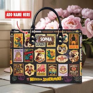 May include: Black handbag with a variety of colorful stamp-like designs. The bag features a top handle, a name tag that says "Sophia", and the text "Neeeeew Achievement!"