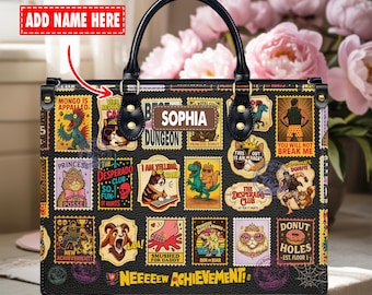 Puede incluir: Bolso negro con una variedad de diseños coloridos en forma de sello. El bolso presenta un asa superior, una etiqueta con el nombre que dice "Sophia" y el texto "Neeeeew Achievement!"