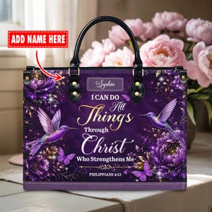 May include: Purple tote bag with black handles, featuring a floral and hummingbird design. The bag has the text "I Can Do All Things Through Christ Who Strengthens Me" and "Philippians 4:13".