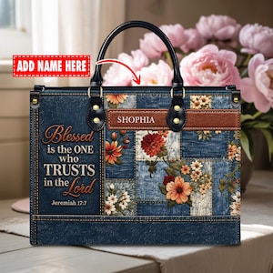 Peut inclure: Un sac à main rectangulaire avec un imprimé patchwork effet jean, des motifs floraux et une bande aspect cuir marron portant le nom SHOPHIA. Le sac affiche le texte Blessed is the ONE who TRUSTS in the Lord Jeremiah 17:7.