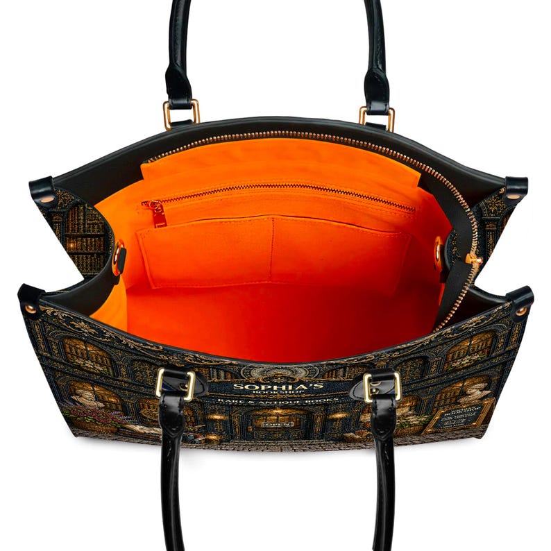 Puede incluir: Bolso tote negro con un dise&ntilde;o detallado de librer&iacute;a. El bolso tiene asas negras y herrajes dorados. El interior es de color naranja brillante con bolsillos y una cremallera. El texto "SOPHIA'S BOOKSHOP RARE & ANTIQUE BOOKS" es visible.