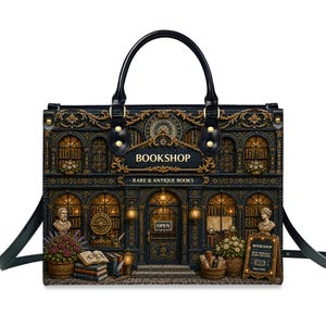 Front view of a vintage bookshop handbag on a white background, featuring an antique bookstore illustration with glowing windows, stacked books, flower baskets, ornate gold details, black handles, and a detachable shoulder strap. Perfect book lover purse, literary tote bag, librarian gift, teacher gift, writer gift, and personalized reader accessory.