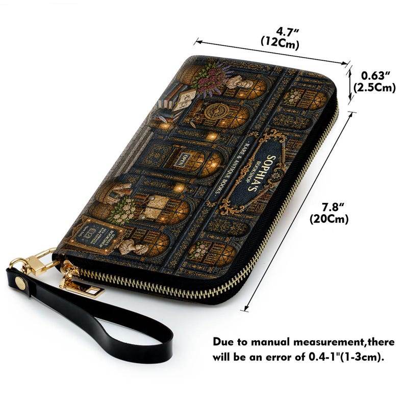 Puede incluir: Una cartera negra con cremallera y dise&ntilde;o de libro, con el texto "SOPHIA'S BOOKSHOP - RARE & ANTIQUE BOOKS". La cartera mide 20 cm de largo, 12 cm de ancho y 2,5 cm de grosor. Tiene una correa de mu&ntilde;eca negra y herrajes dorados.