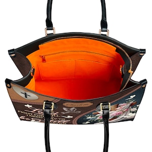 Overhead view showing the spacious interior of the Christian handbag. The bright orange lining includes a large main compartment, one zippered pocket, and two slip pockets for organization, making it a functional church or work tote