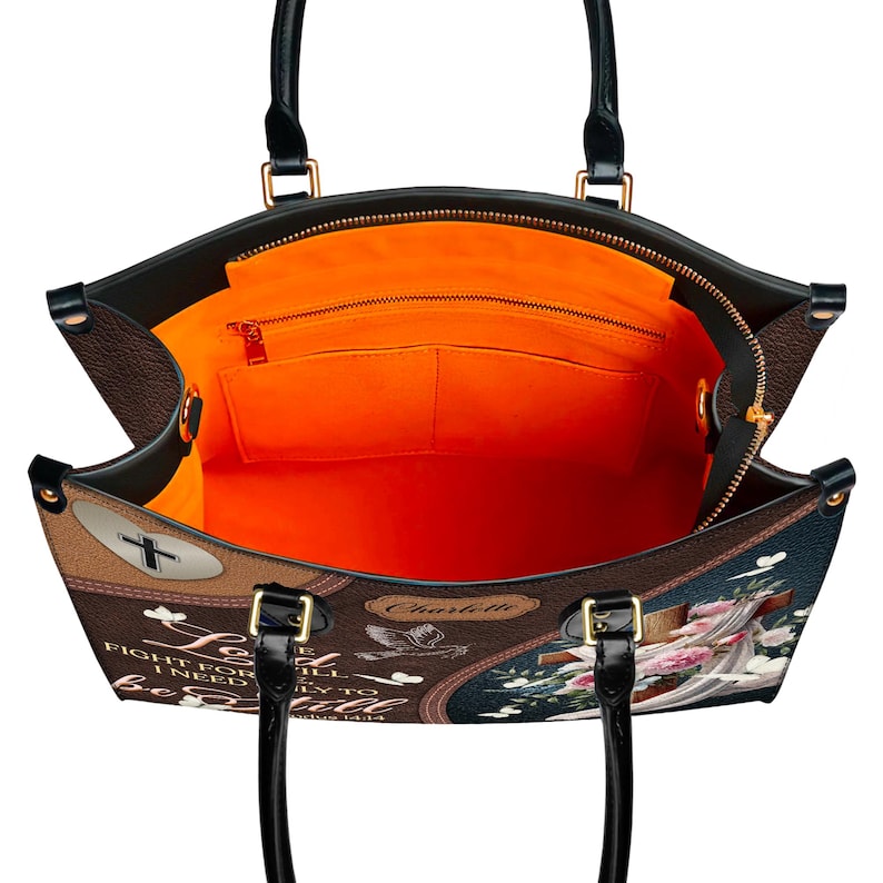 Overhead view showing the spacious interior of the Christian handbag. The bright orange lining includes a large main compartment, one zippered pocket, and two slip pockets for organization, making it a functional church or work tote