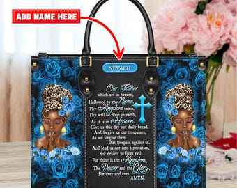 May include: Black tote bag with a floral and portrait design. The bag features a black handle and a flap with the name "NEVAEH". The design includes a portrait of a woman, blue roses, and religious text.