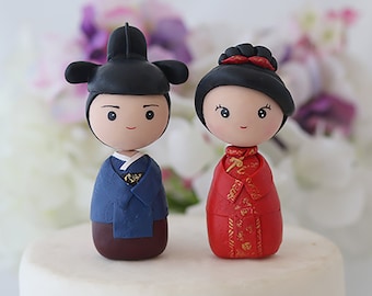 Figurines kokeshi de gâteau de mariage de mariée chinoise et de marié coréen