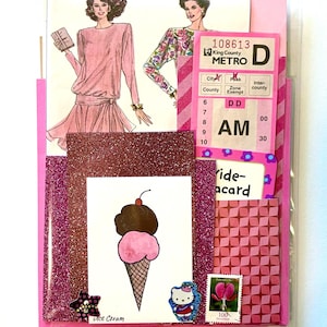 Mystery ephemera pack in Pink, showing vintage texts, sewing pattern pictures, decorative papers, art print with pink ice cream, vintage paper bus transfer, cancelled postage stamp, and stickers.