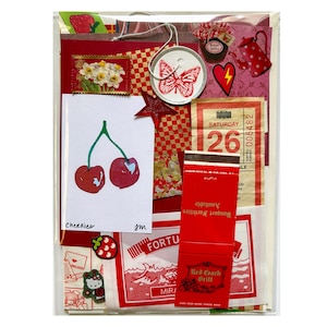 Mystery ephemera pack in Red, showing vintage texts, decorative papers, print with cherries, red matchbook cover, vintage SF muni paper transfer, and stickers.
