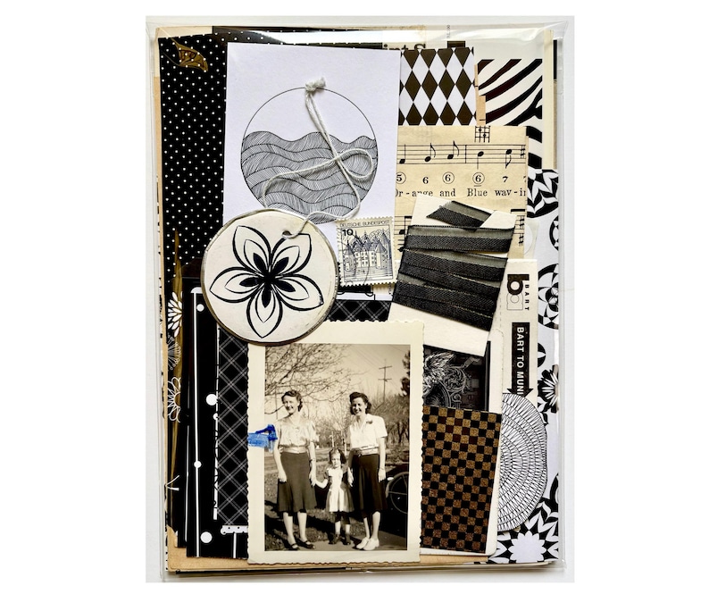 Mystery ephemera pack in Black and White, showing sheet music, decorative papers, art print with waves, vintage photo, black ribbon, and stickers.