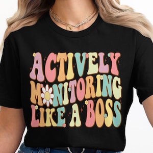 May include: Black t-shirt with a colorful retro graphic that says "Actively Monitoring Like a Boss".