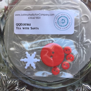 May include: A package of red and white buttons with a snowflake and the text "QQD.10361 TEA WITH SANTA" and "Just Another Button Company.com 618-667-8531"