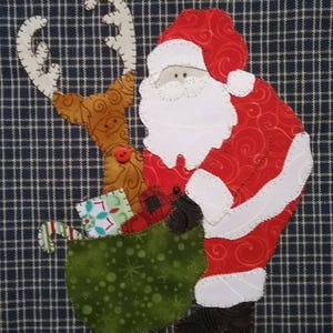 May include: A red and white Santa Claus figure with a white beard and a brown reindeer with antlers. Santa is holding a green bag with presents inside. The figures are on a blue and white checked background.