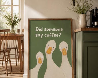 Può includere: Una stampa artistica rettangolare incorniciata raffigurante tre oche bianche con becchi arancioni su uno sfondo verde salvia a tinta unita. Il testo "Did someone say coffee?" è stampato in lettere bianche arrotondate e senza grazie.