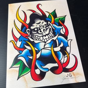 May include: A colourful illustration on paper featuring a central blue rose with a stylised gorilla face emerging from the centre. The design includes vibrant red and yellow flame-like accents, green leaves, and the initials JG with a signature.