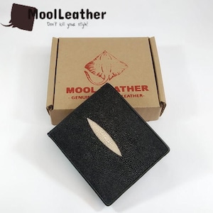 May include: Black leather wallet with a central white stripe, presented on a brown cardboard box. The box features a stingray graphic and the text "MOOL LEATHER". The wallet has a textured surface.