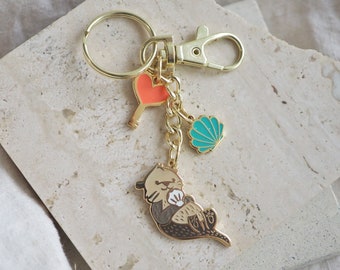 Sea Otter Keychain with a White Shell | Gold Key Fob - glow-in-the-dark