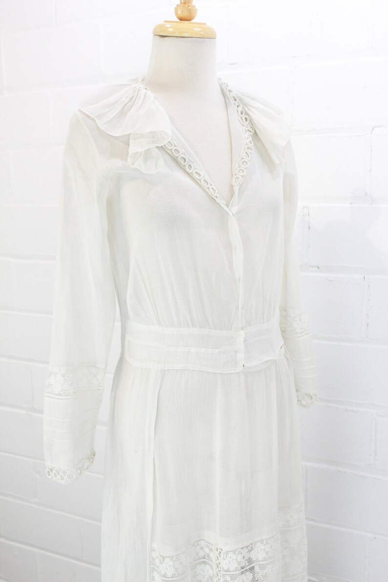 edwardian cotton lawn dress with ruffle collar, loop embroidered trim on sleeves and v neckline, floral embroidered skirt, long sleeves, maxi length, hooks and eyes closure