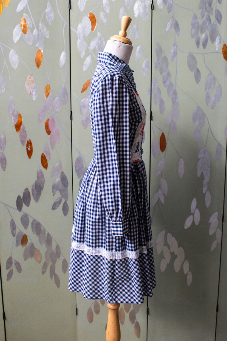 1970s blue white gingham check button up shirt dress with large collar, red and white contrast check patchwork squares and lace border on front, gathered skirt, long sleeves coastal cowgirl