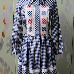 1970s blue white gingham check button up shirt dress with large collar, red and white contrast check patchwork squares and lace border on front, gathered skirt, long sleeves coastal cowgirl