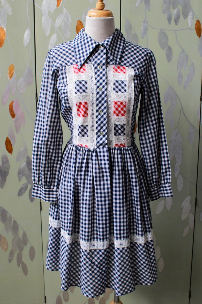 1970s blue white gingham check button up shirt dress with large collar, red and white contrast check patchwork squares and lace border on front, gathered skirt, long sleeves coastal cowgirl