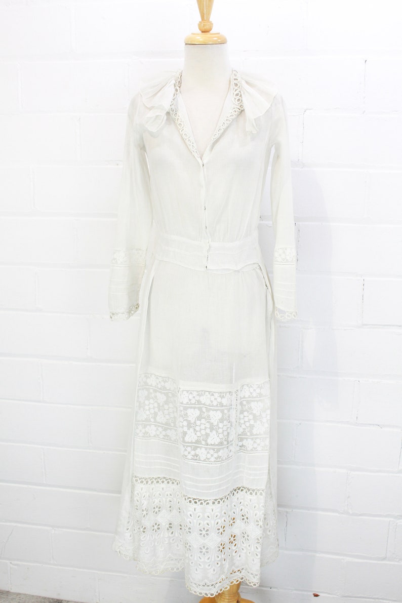 edwardian cotton lawn dress with ruffle collar, loop embroidered trim on sleeves and v neckline, floral embroidered skirt, long sleeves, maxi length, hooks and eyes closure  antique bridal dress