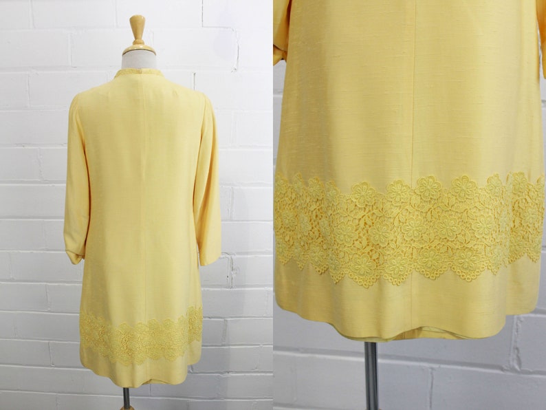 May include: A yellow dress with a lace trim. The dress has a long sleeve and a fitted bodice. The lace trim is a delicate floral pattern.
