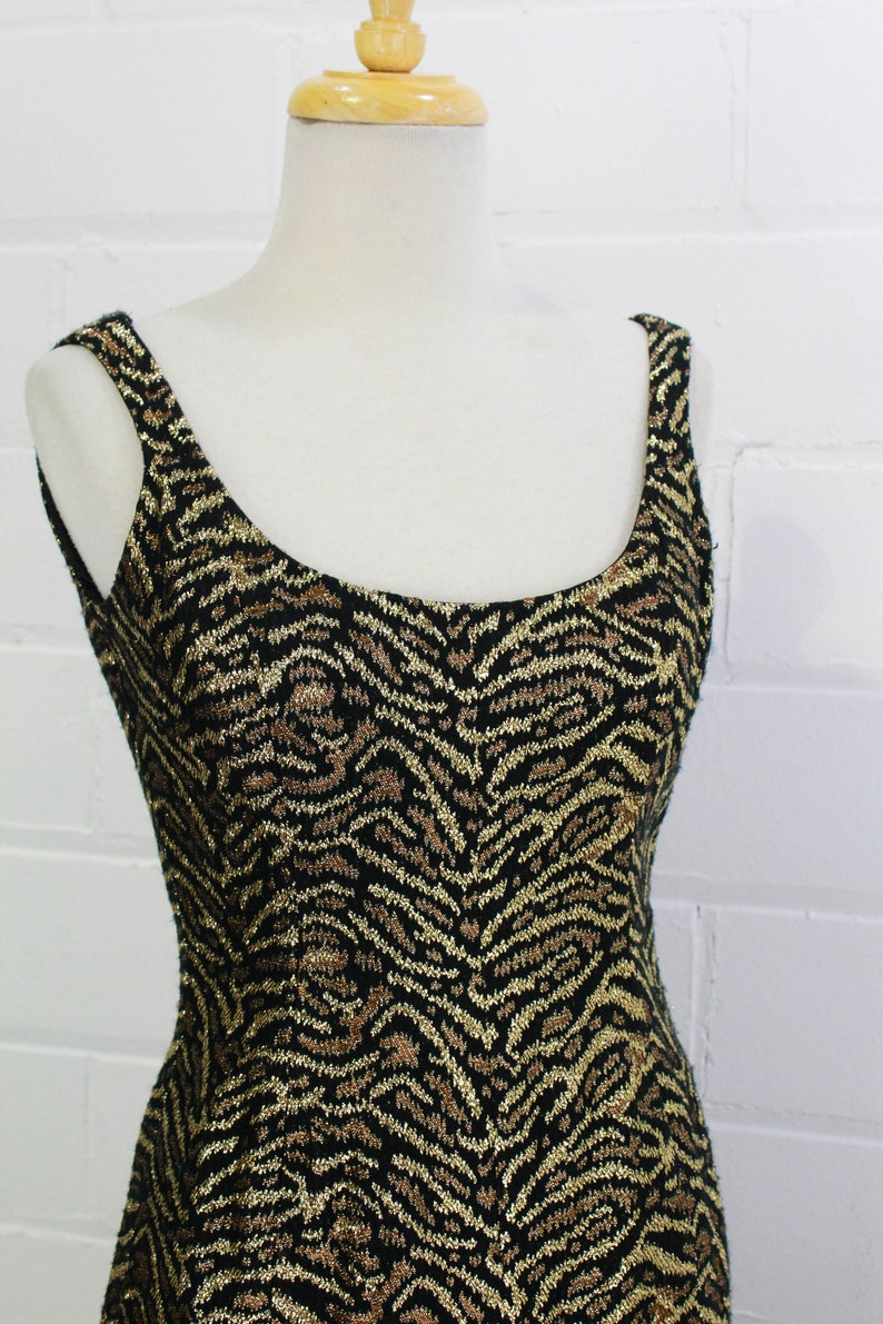May include: A sleeveless dress with a black and gold zebra print pattern.