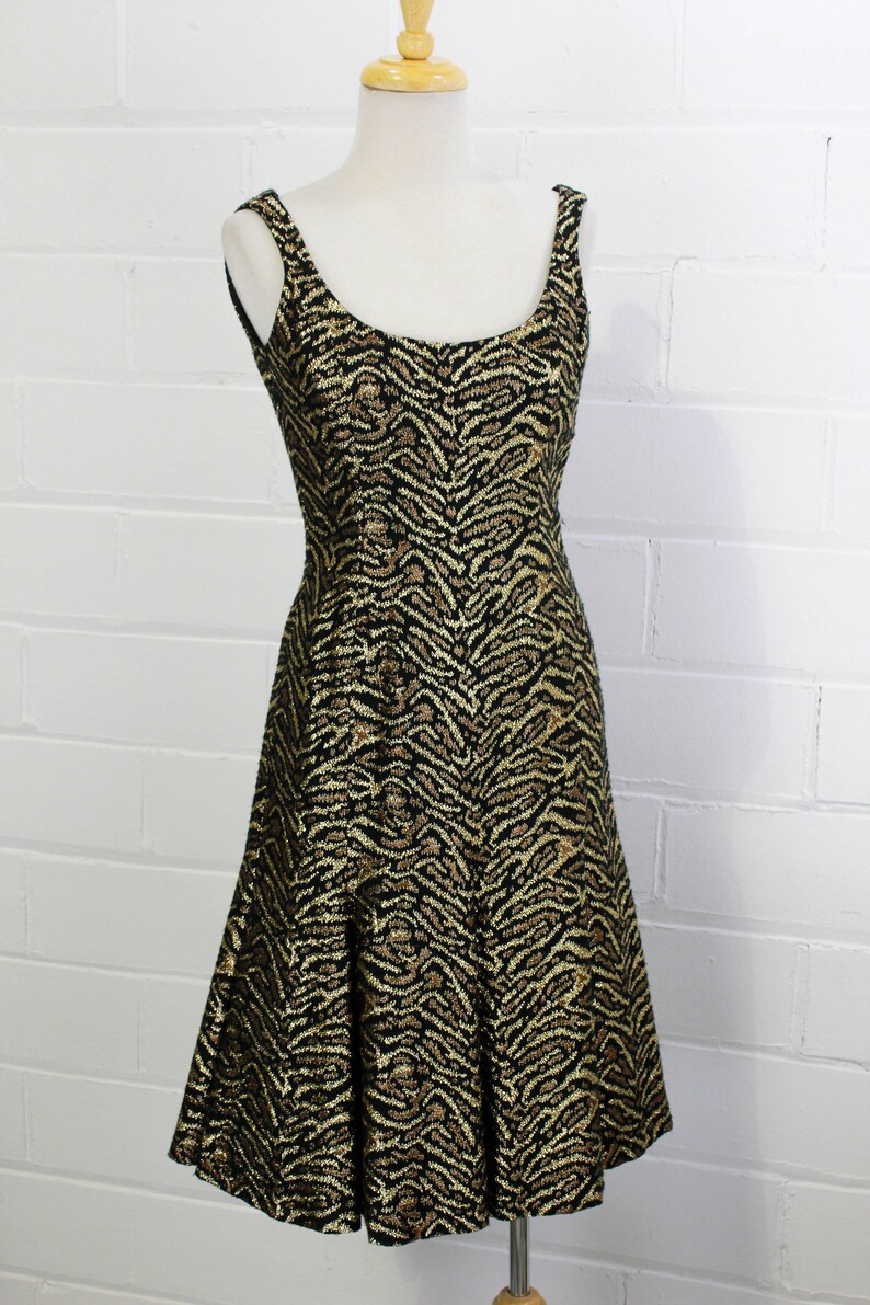 May include: A black and gold sleeveless dress with a tiger print pattern.
