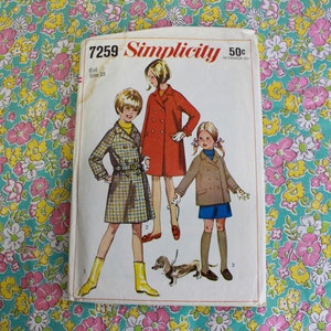 May include: Vintage Simplicity sewing pattern 7259 for girls' coats. The pattern features three girls wearing different styles of coats, including a plaid coat with a belt, a red double-breasted coat, and a brown double-breasted coat. The pattern is printed on a white background with a floral design.