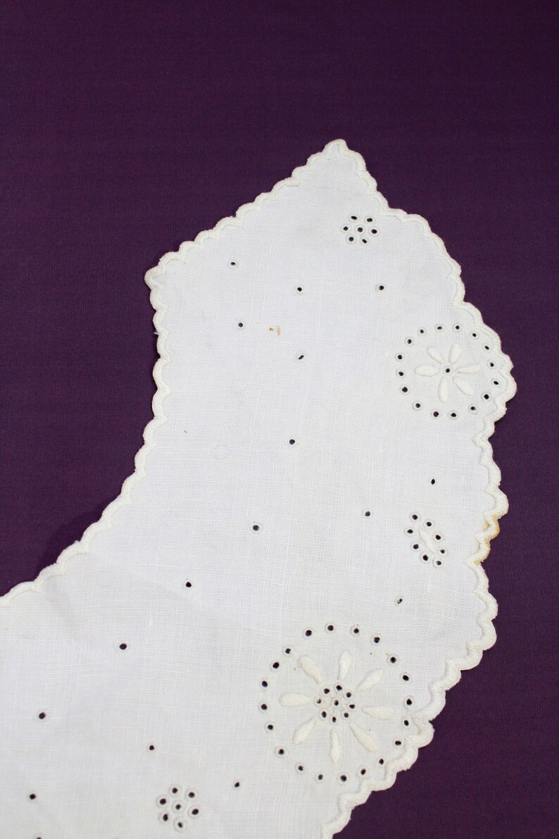 May include: White cotton lace collar with scalloped edges and delicate embroidered floral designs.