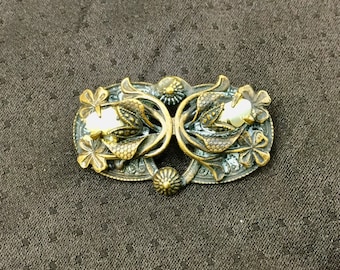 May include: A vintage gold-toned brooch with a floral design and two faux pearl accents.