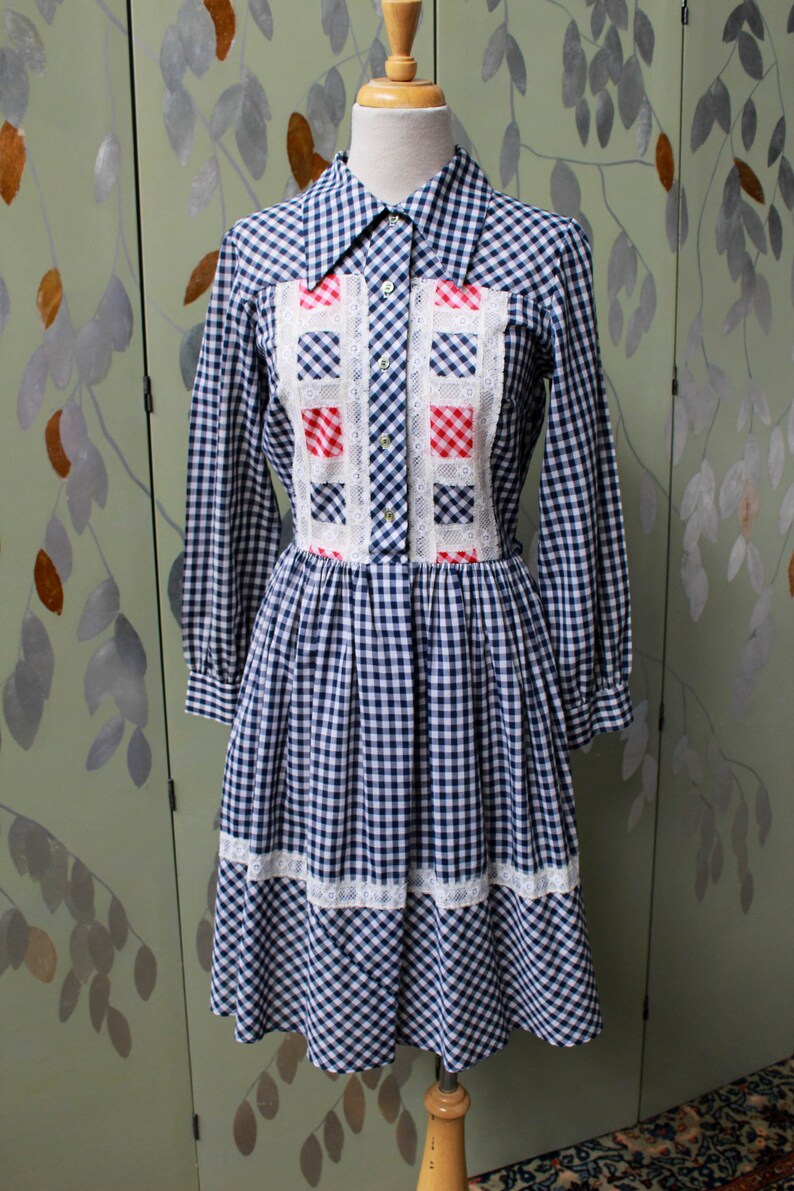 1970s blue white gingham check button up shirt dress with large collar, red and white contrast check patchwork squares and lace border on front, gathered skirt, long sleeves coastal cowgirl
