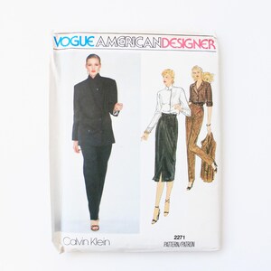 May include: A vintage Vogue American Designer sewing pattern featuring a black suit and a skirt and blouse ensemble. The pattern is for size 2271 and is designed by Calvin Klein.